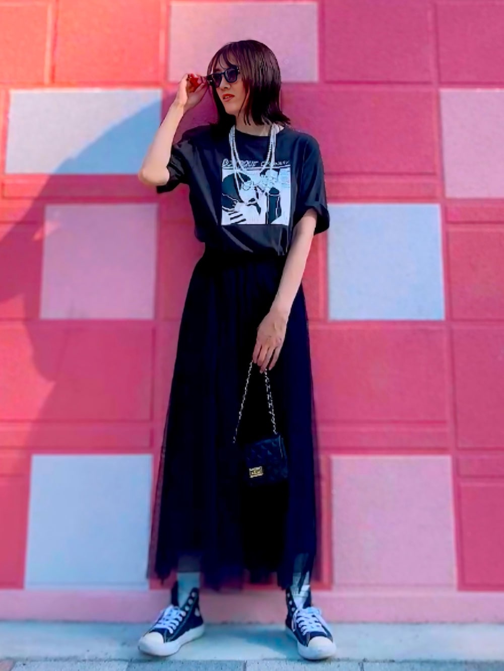 ブラック系のTシャツ/カットソー、ブラック系のスカート、ブラック系のショルダーバッグを着用したレディースの夏コーディネートの2枚目の写真