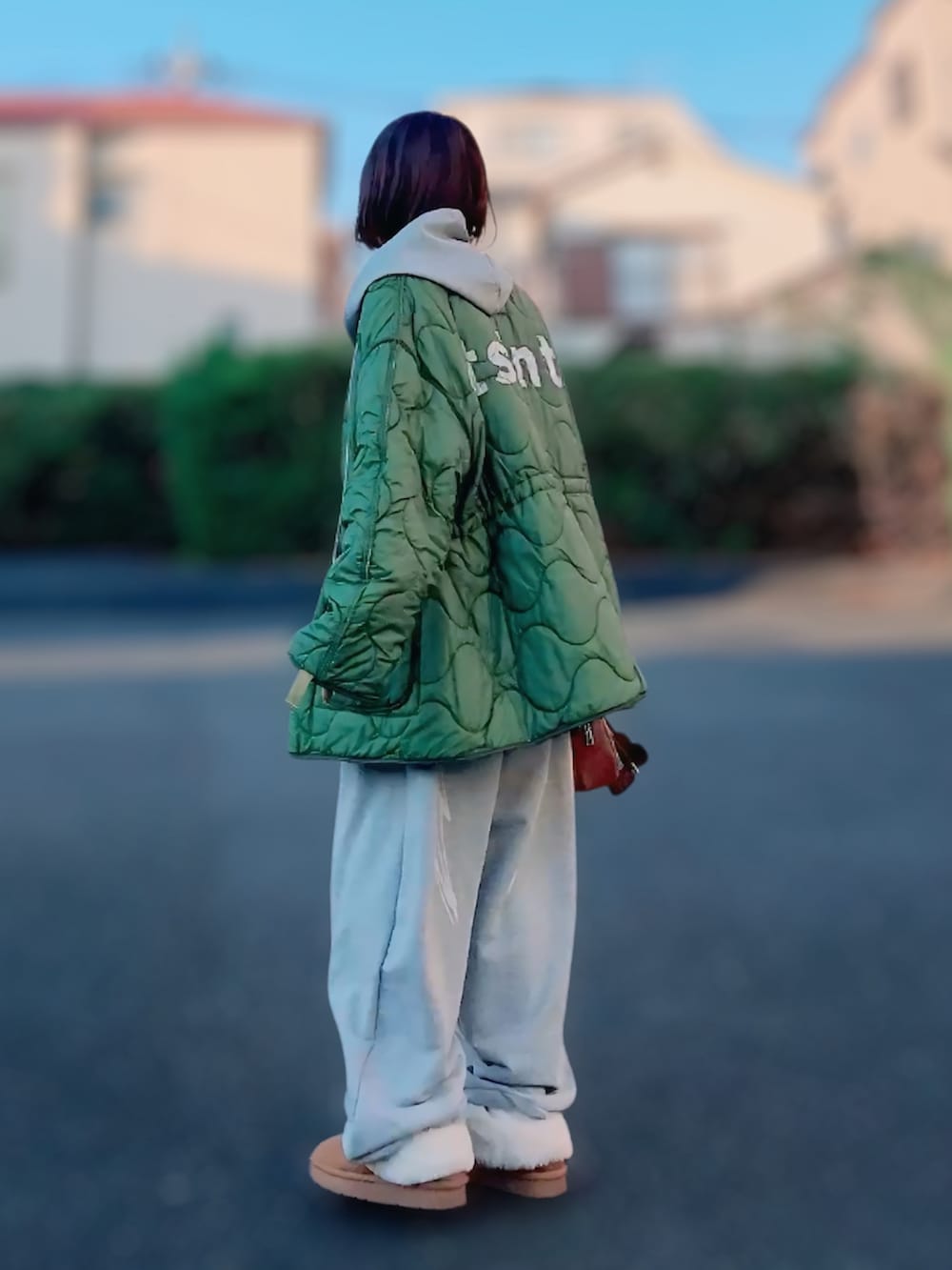 グレー系のパーカー、グレー系のスウェットパンツ、ブラウン系のボストンバッグを着用したレディースの冬コーディネートの3枚目の写真