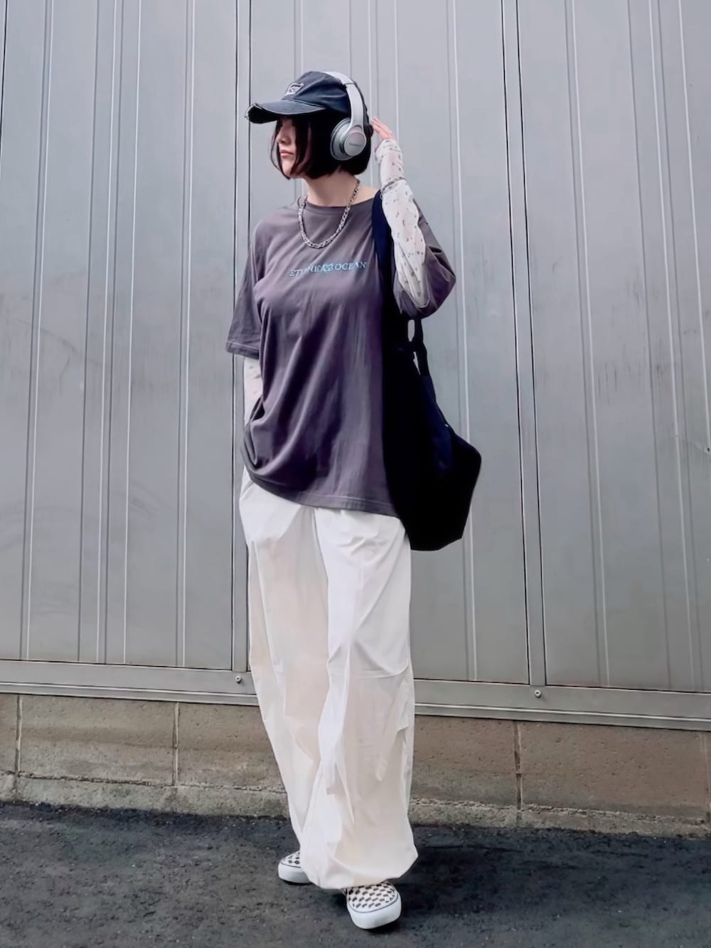 ブラック系のショルダーバッグ、ホワイト系のTシャツ/カットソー、ブラック系のスリッポンを着用したレディースの夏コーディネートの2枚目の写真