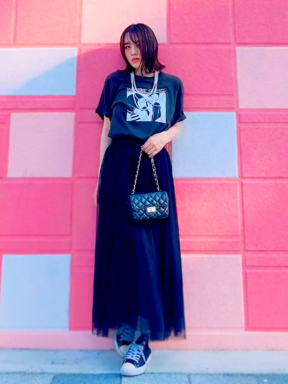 ブラック系のTシャツ/カットソー、ブラック系のスカート、ブラック系のショルダーバッグを着用したレディースの夏コーディネートの3枚目の写真