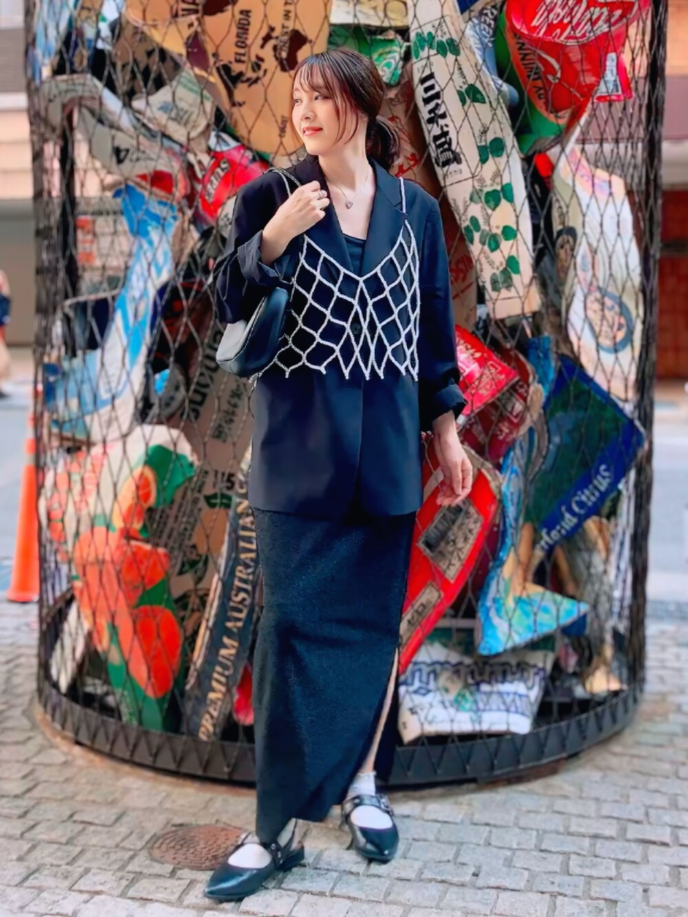 ブラック系のノーカラージャケット、ブラック系のスカート、ホワイト系のベストを着用したレディースの秋コーディネートの2枚目の写真