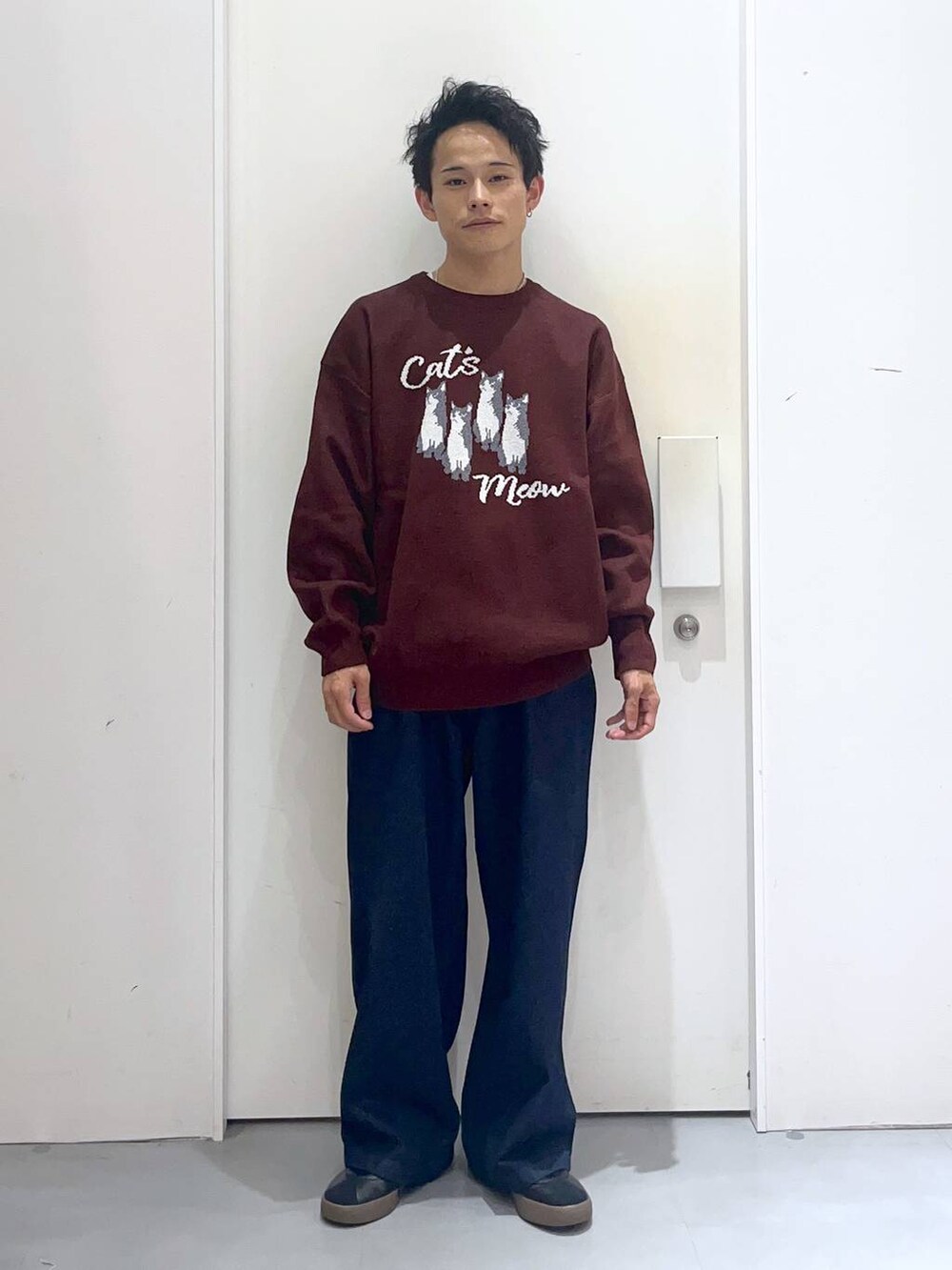 ブラウン系のニット/セーター、ブルー系のデニムパンツ、ブラック系のブルゾンを着用したメンズの秋コーディネートの4枚目の写真