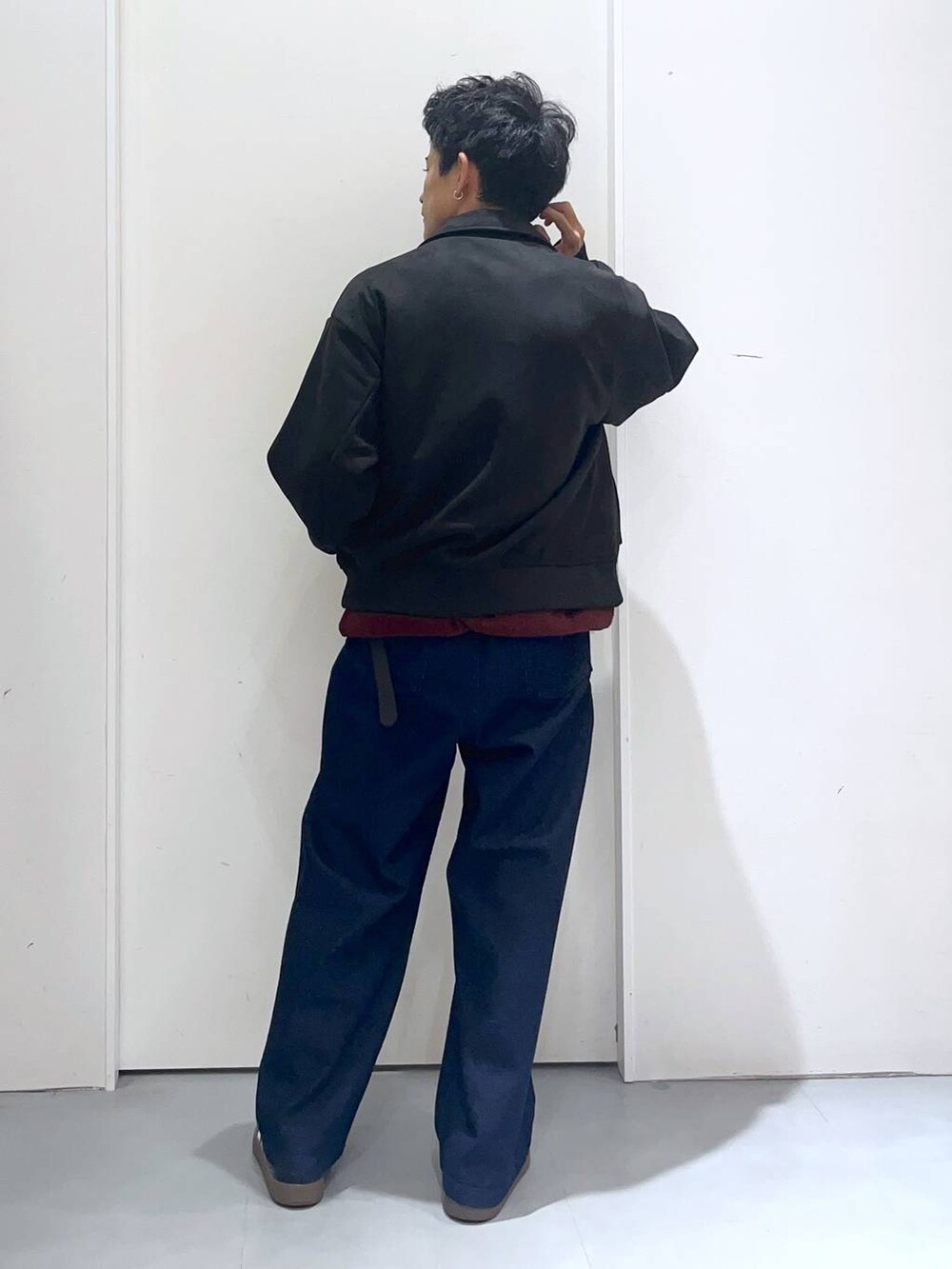 ブラウン系のニット/セーター、ブルー系のデニムパンツ、ブラック系のブルゾンを着用したメンズの秋コーディネートの6枚目の写真