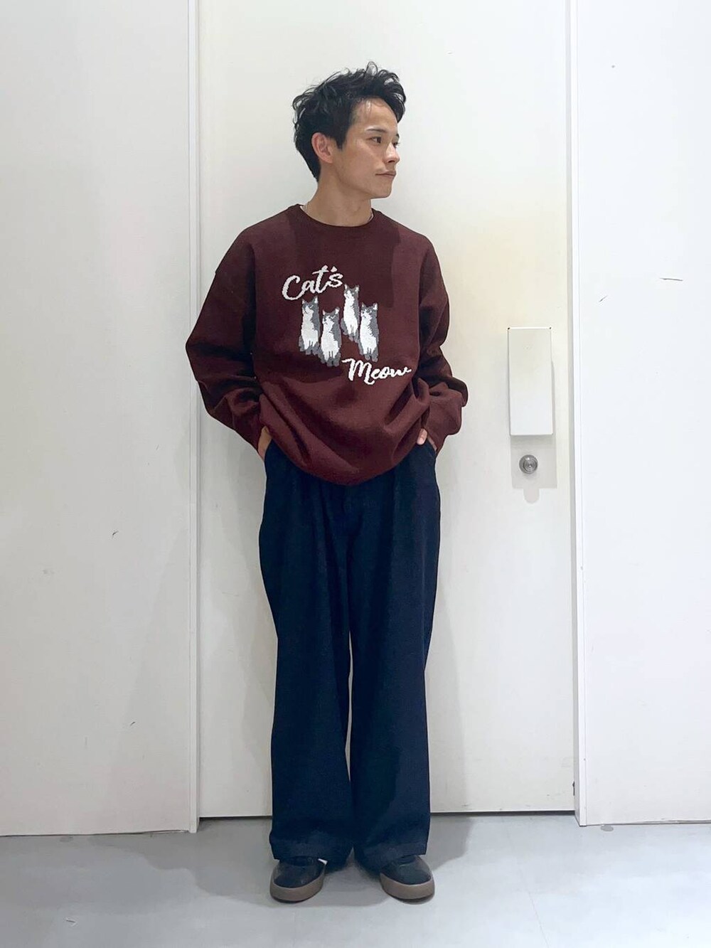 ブラウン系のニット/セーター、ブルー系のデニムパンツ、ブラック系のブルゾンを着用したメンズの秋コーディネートの3枚目の写真