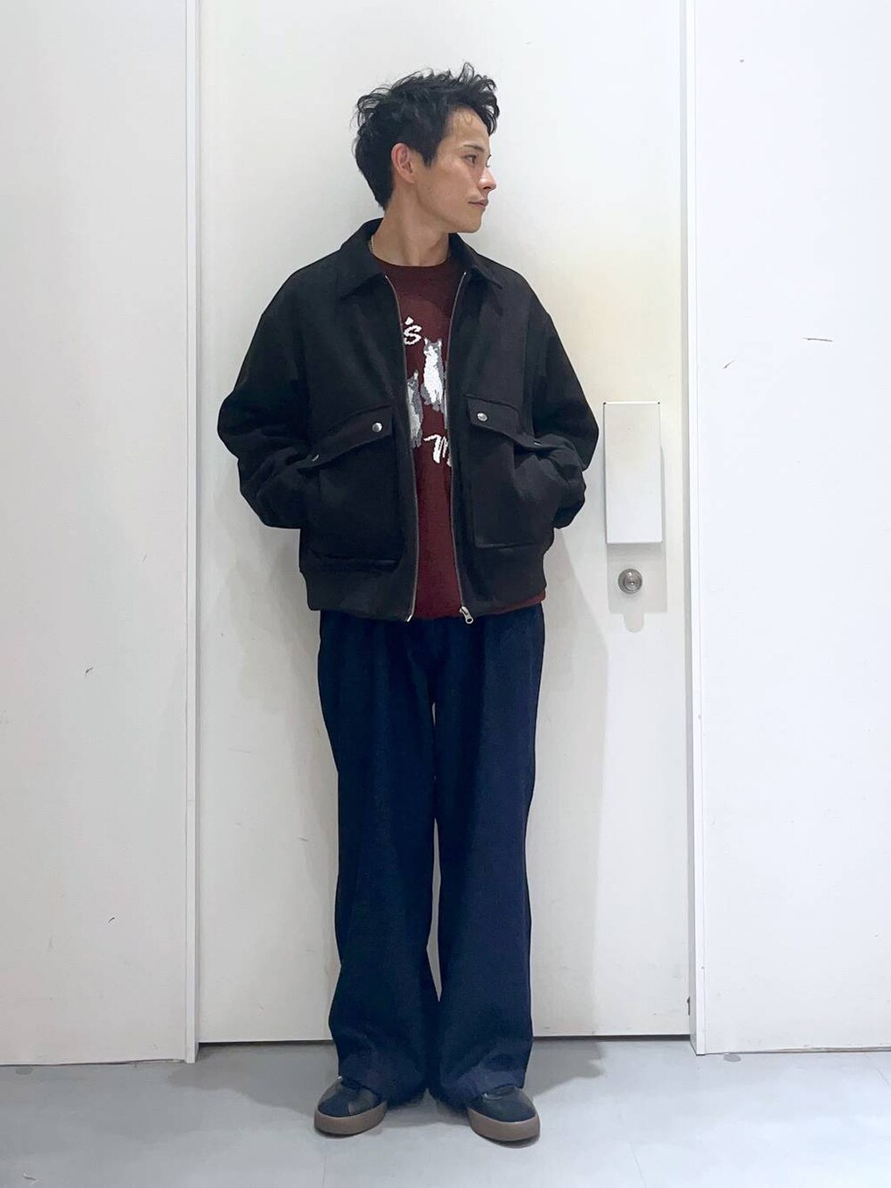 ブラウン系のニット/セーター、ブルー系のデニムパンツ、ブラック系のブルゾンを着用したメンズの秋コーディネートの5枚目の写真