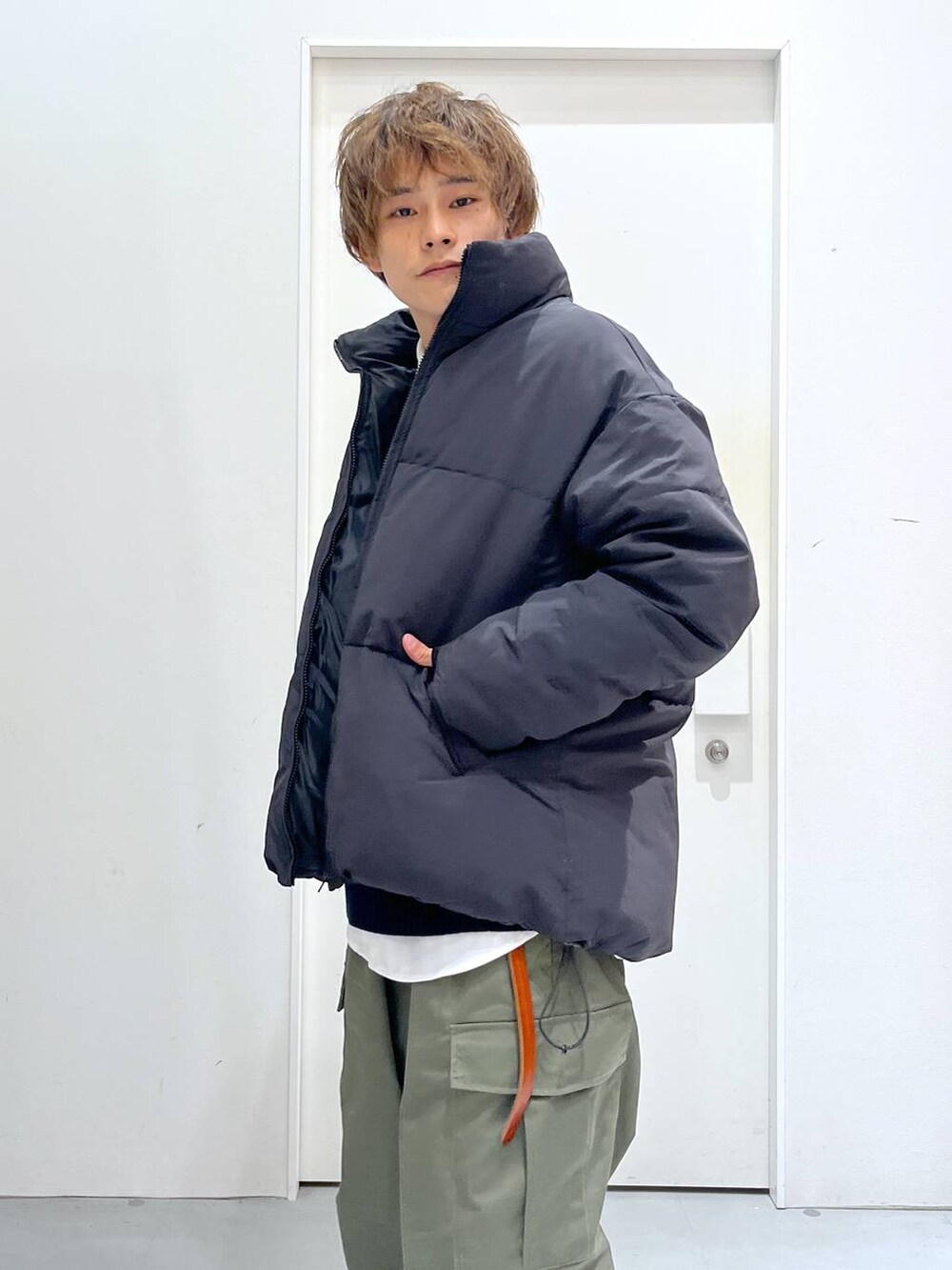 ブラック系のその他アウター、グリーン系のカーゴパンツ、ブルー系のニット/セーターを着用したメンズの冬コーディネートの2枚目の写真