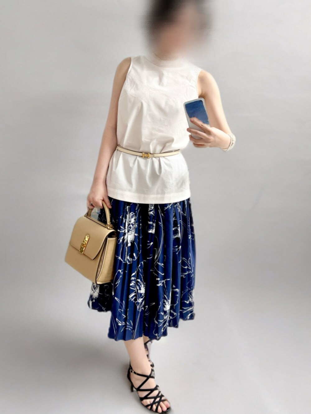 ホワイト系のトップス、ブルー系のスカート、ベージュ系のバッグを着用したレディースの夏コーディネートの2枚目の写真