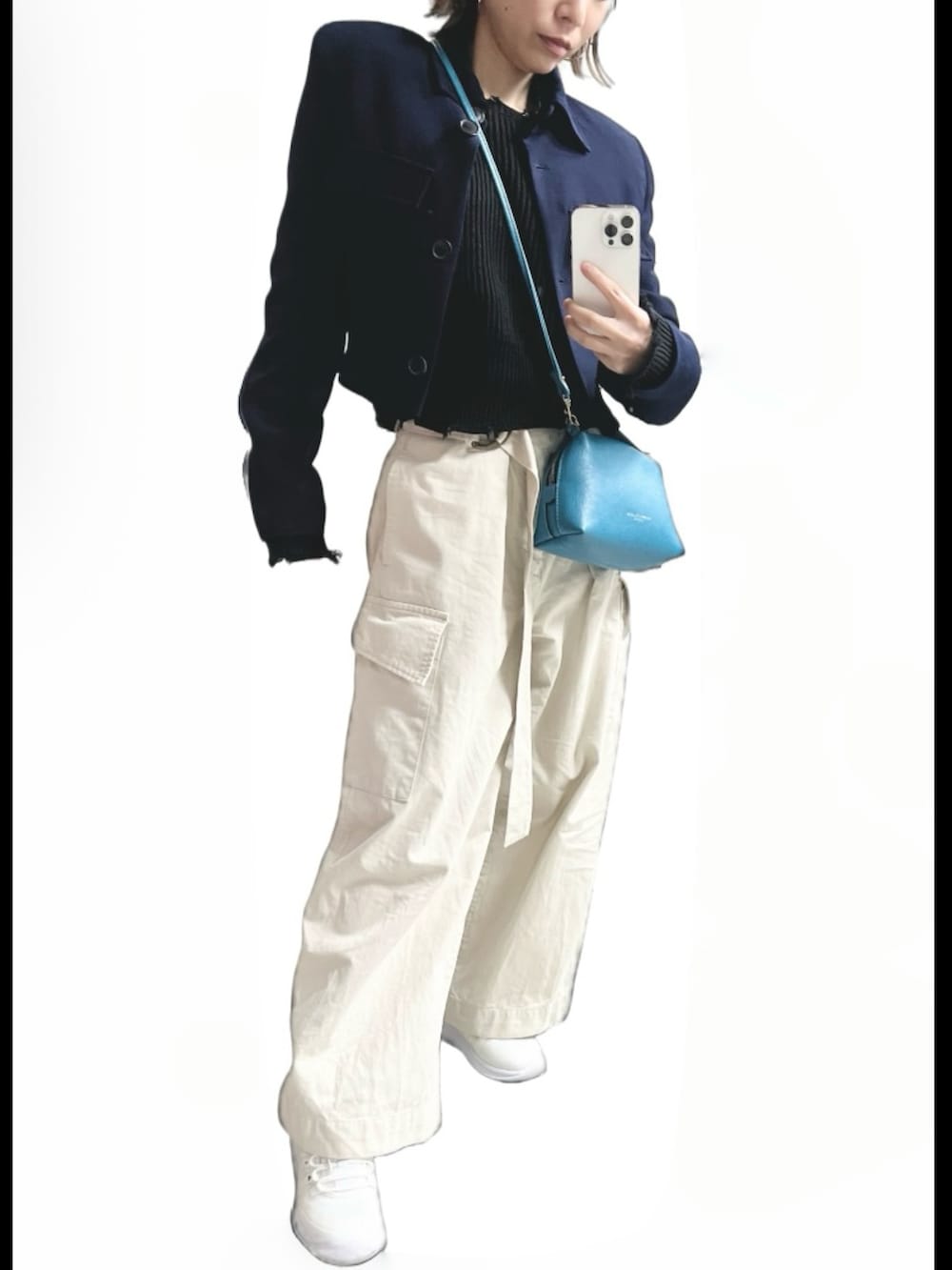 ベージュ系のパンツ、ホワイト系のスニーカー、ブルー系のバッグを着用したレディースの春コーディネートの2枚目の写真