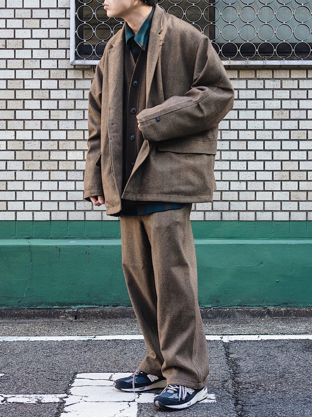 ブラウン系のジャケット/アウター、ブラウン系のパンツ、ブルー系のスニーカーを着用したメンズの冬コーディネートの2枚目の写真