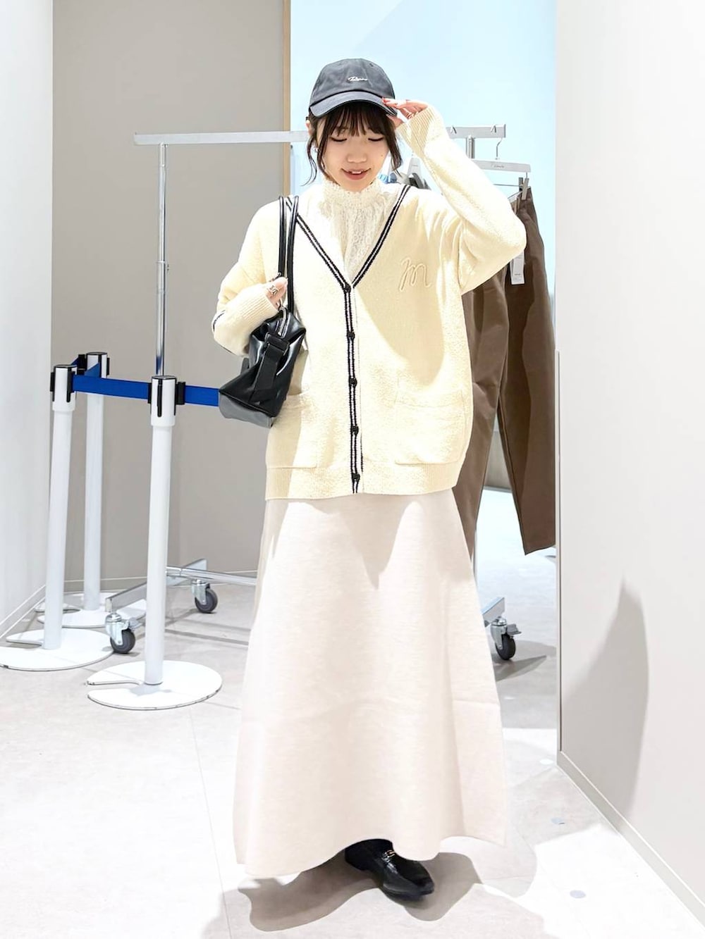 ブラック系のローファー、ホワイト系のシャツ/ブラウス、ベージュ系のスカートを着用したレディースの春コーディネートの2枚目の写真