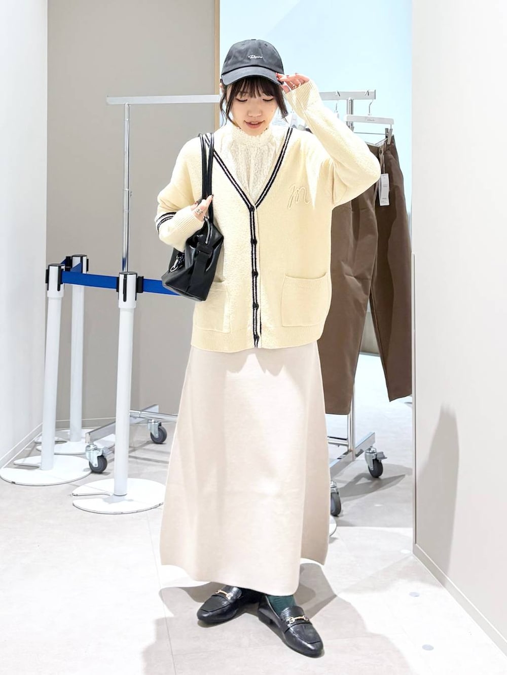 ブラック系のローファー、ホワイト系のシャツ/ブラウス、ベージュ系のスカートを着用したレディースの春コーディネートの7枚目の写真