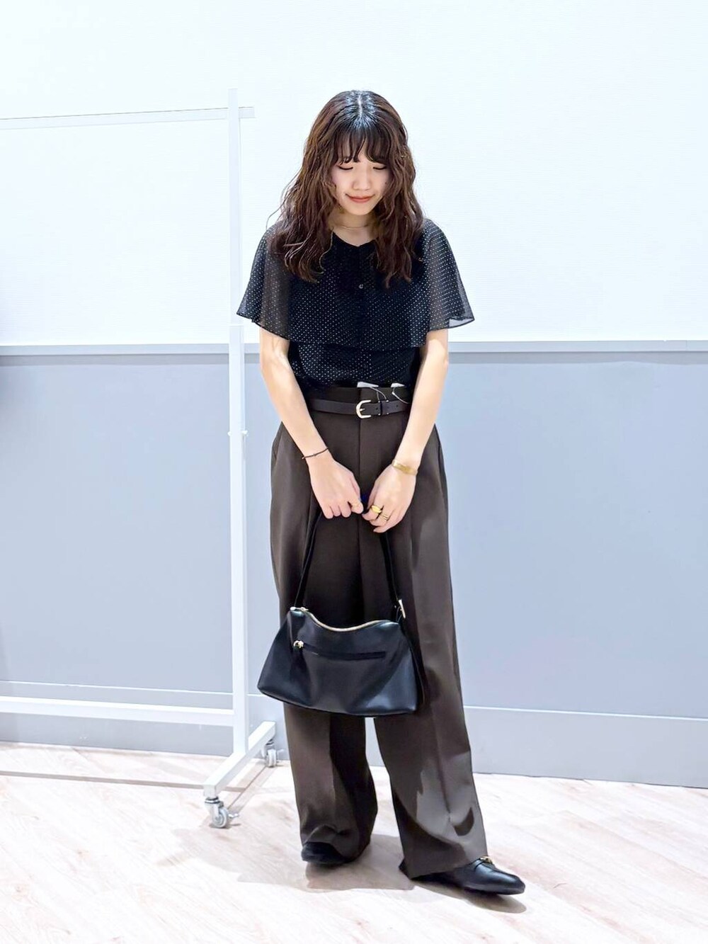 ブラック系のローファー、ブラック系のショルダーバッグ、ブラウン系のベルトを着用したレディースの春コーディネートの2枚目の写真