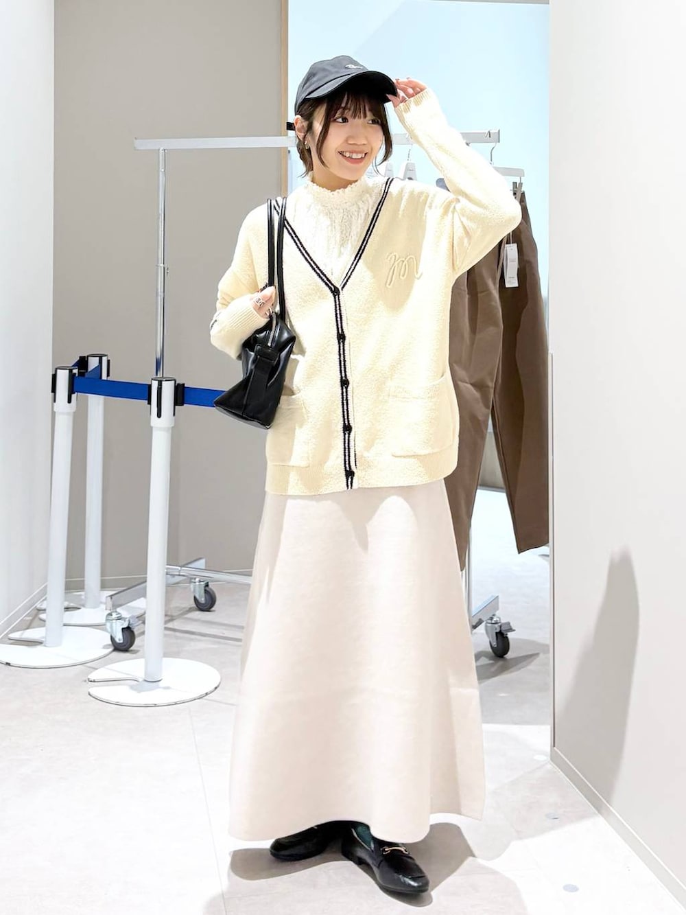 ブラック系のローファー、ホワイト系のシャツ/ブラウス、ベージュ系のスカートを着用したレディースの春コーディネートの3枚目の写真