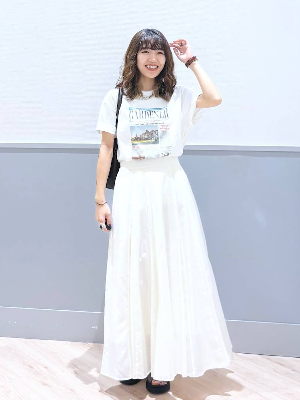 ホワイト系のスカート、ブラウン系のサンダル、ブラウン系のボストンバッグを着用したレディースの秋コーディネートの9枚目の写真