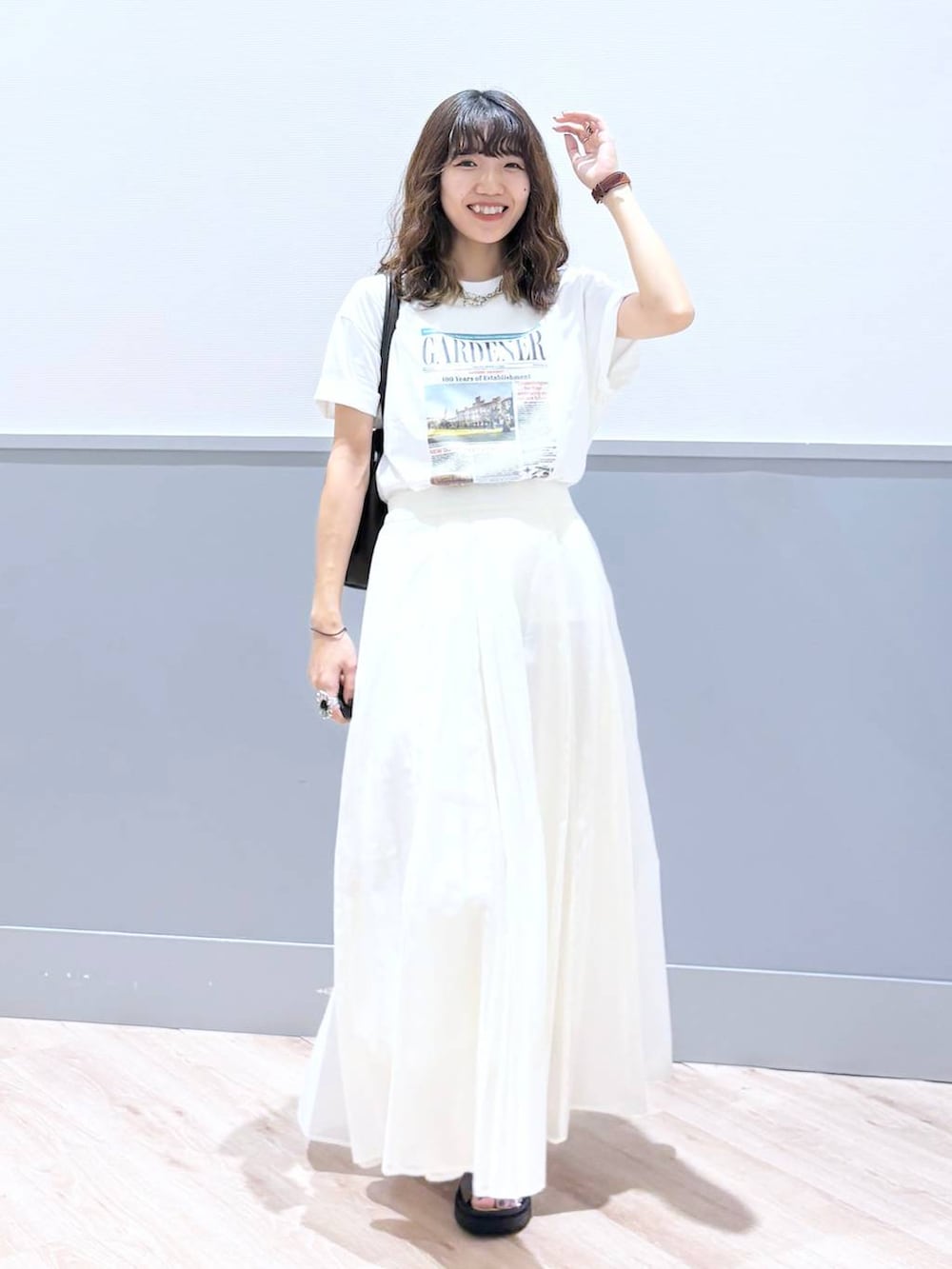 ホワイト系のスカート、ブラウン系のサンダル、ブラウン系のボストンバッグを着用したレディースの秋コーディネートの8枚目の写真