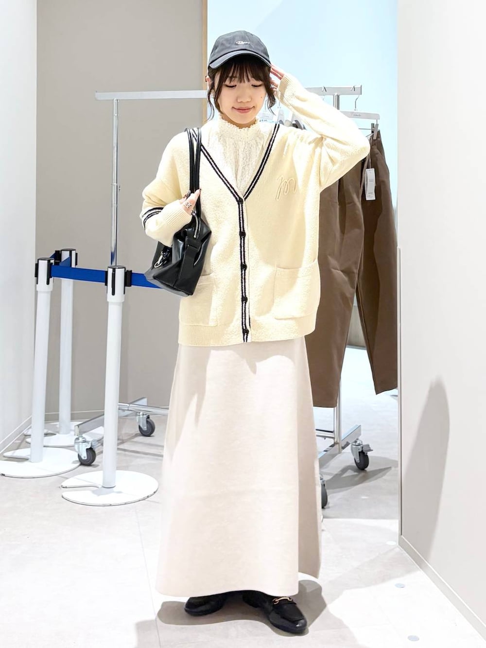 ブラック系のローファー、ホワイト系のシャツ/ブラウス、ベージュ系のスカートを着用したレディースの春コーディネートの6枚目の写真