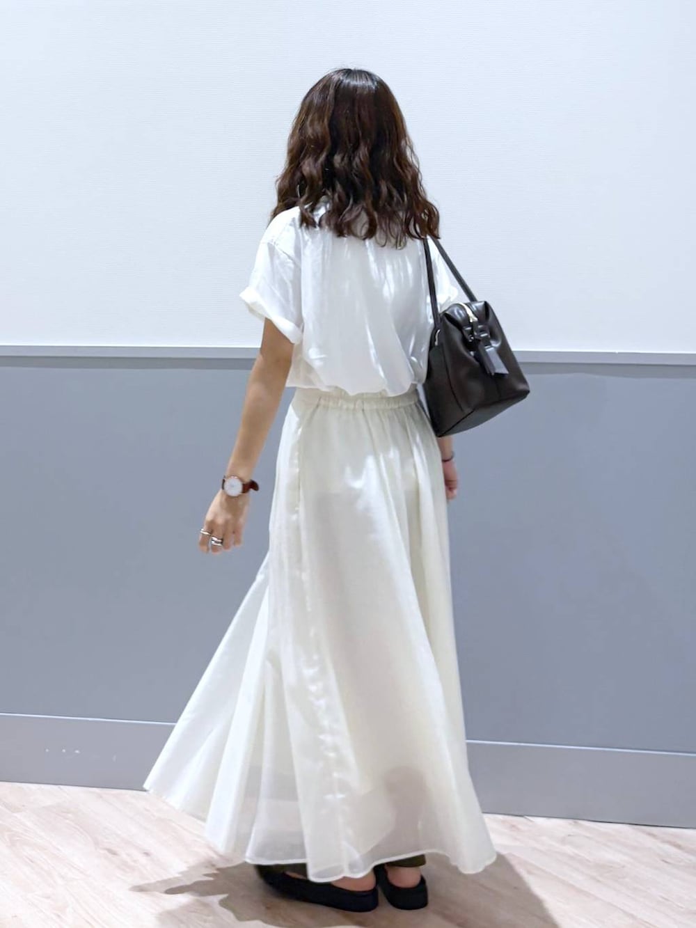 ホワイト系のスカート、ブラウン系のサンダル、ブラウン系のボストンバッグを着用したレディースの秋コーディネートの4枚目の写真