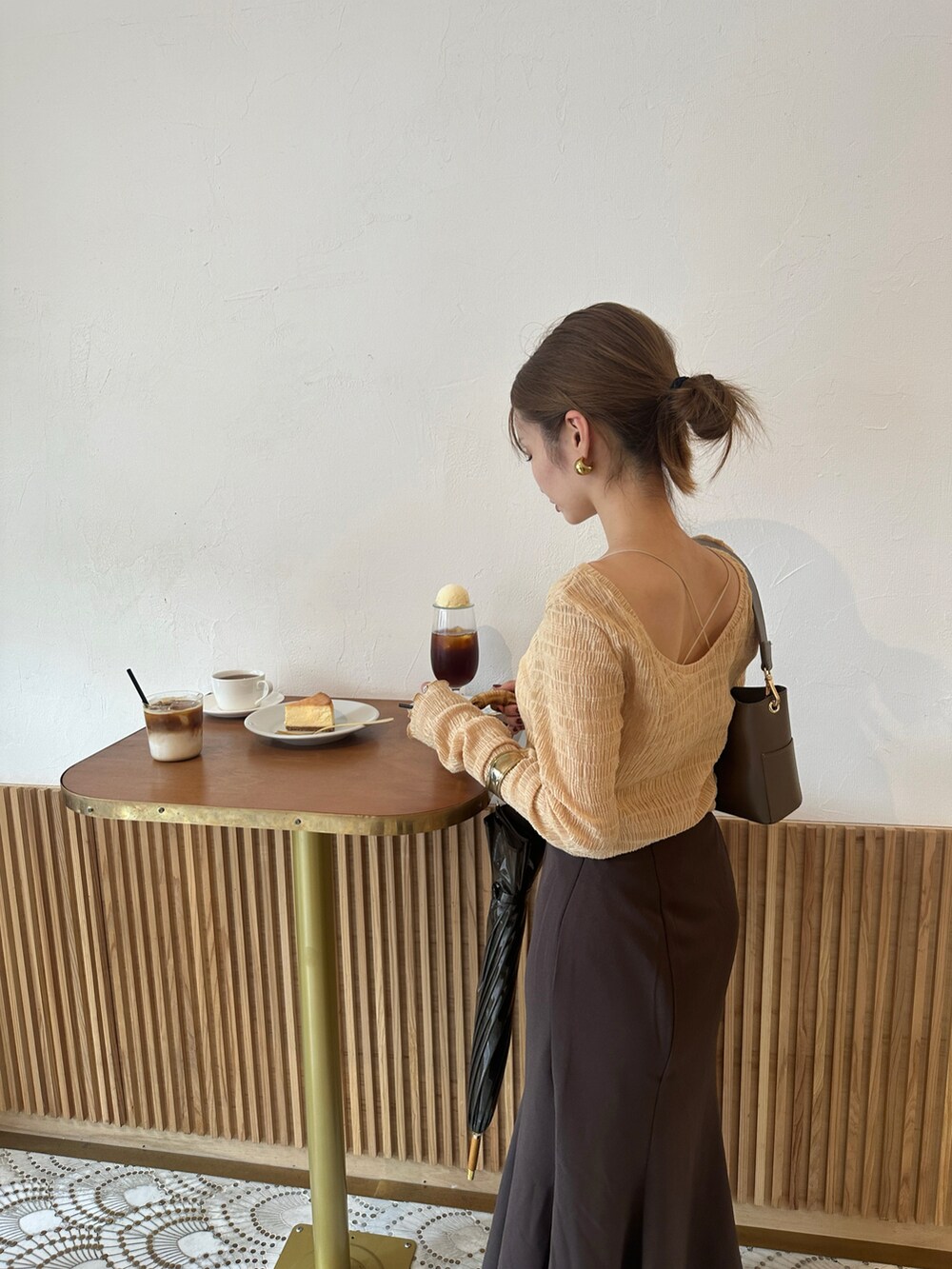レッド系のブーツ、オレンジ系のTシャツ/カットソー、ブラウン系のスカートを着用したレディースの秋コーディネートの2枚目の写真