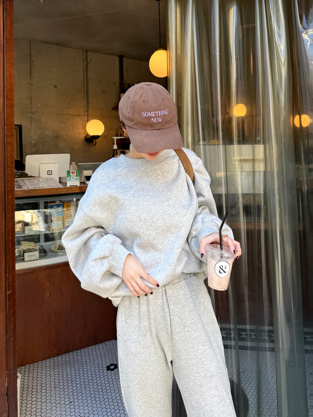 ブラウン系のスニーカー、グレー系のスウェット、グレー系のスウェットパンツを着用したレディースの秋コーディネートの2枚目の写真