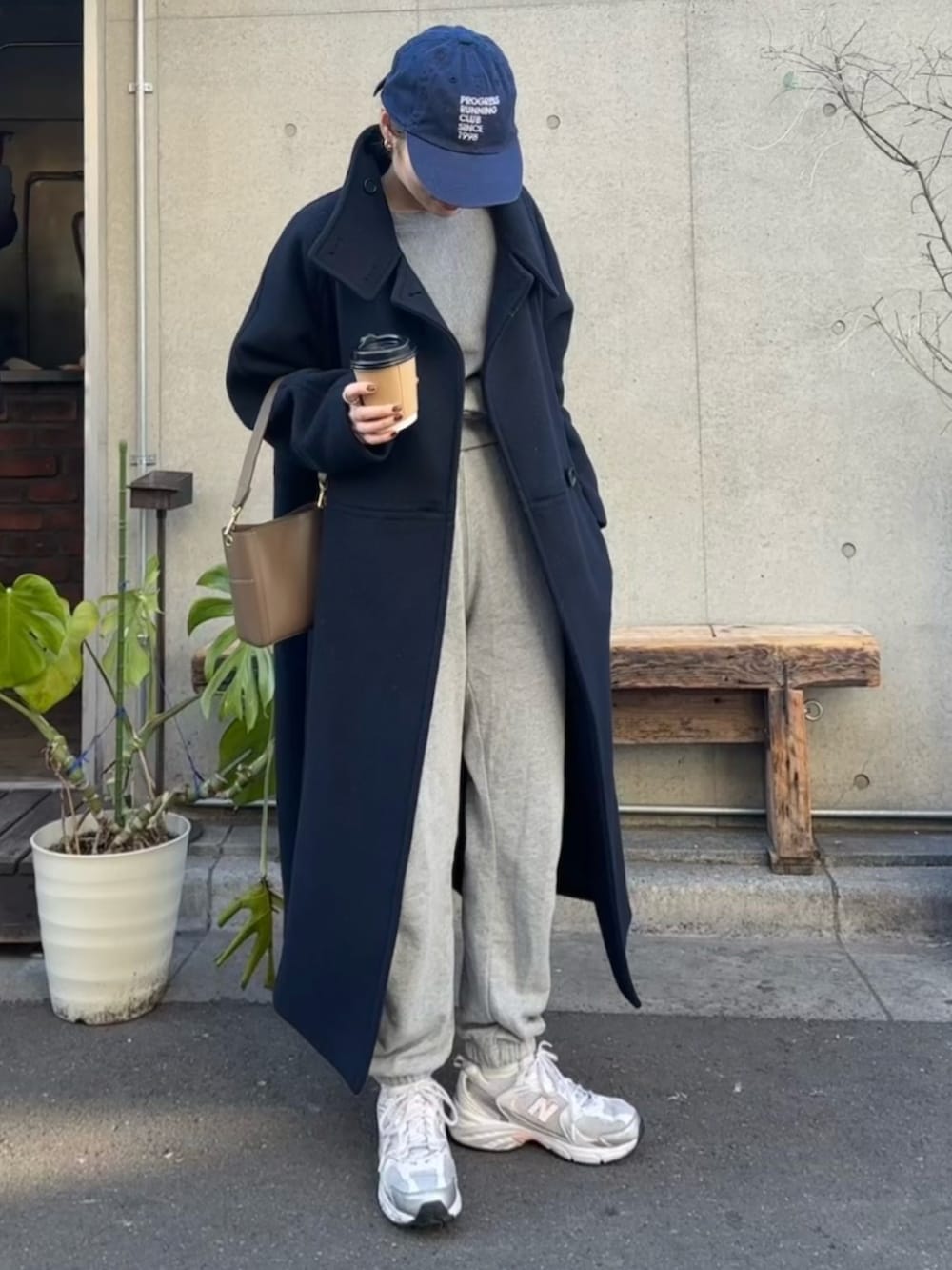 グレー系のスウェットパンツ、グレー系のスウェット、ホワイト系のスニーカーを着用したレディースの冬コーディネートの2枚目の写真