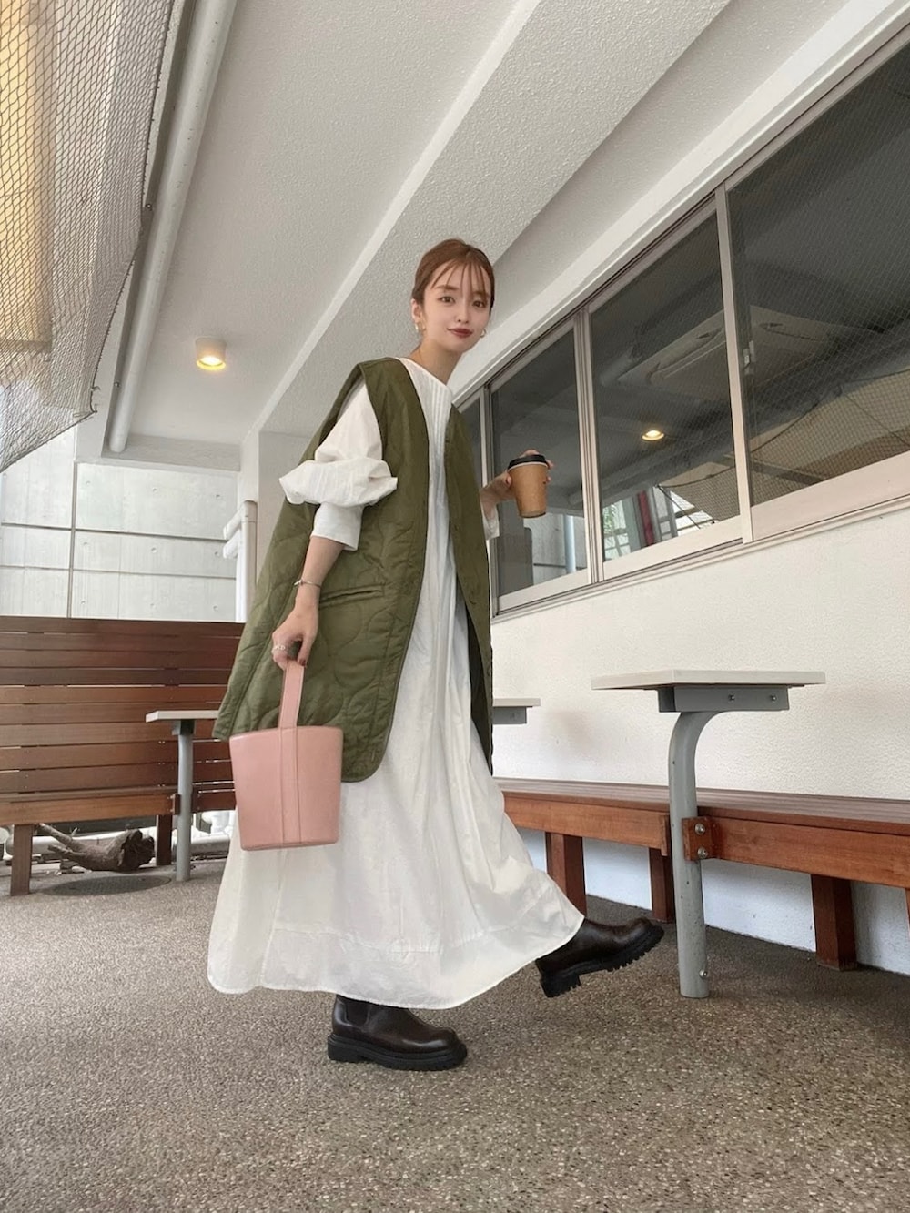 レッド系のブーツ、ベージュ系のシャツワンピース、ピンク系のバッグを着用したレディースの秋コーディネートの3枚目の写真