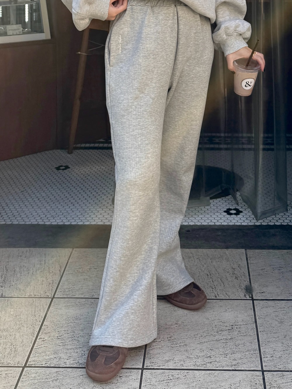 ブラウン系のスニーカー、グレー系のスウェット、グレー系のスウェットパンツを着用したレディースの秋コーディネートの4枚目の写真