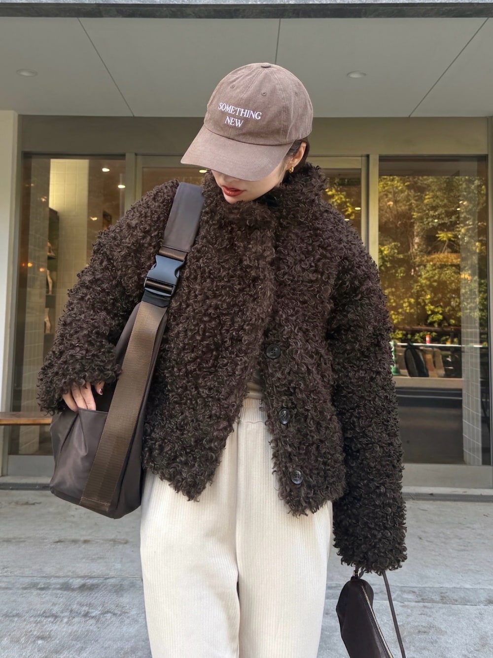 ホワイト系のスウェットパンツ、ブラウン系のブーツ、ブラウン系のブルゾンを着用したレディースの冬コーディネートの4枚目の写真