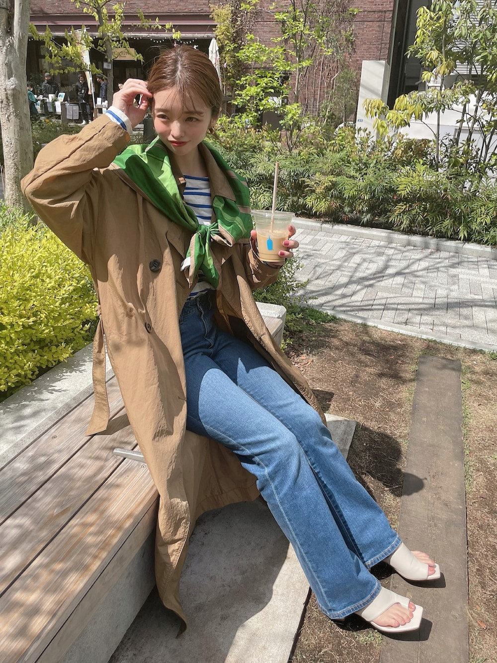 ホワイト系のサンダル、ホワイト系のTシャツ/カットソー、ベージュ系のトレンチコートを着用したレディースの春コーディネートの2枚目の写真