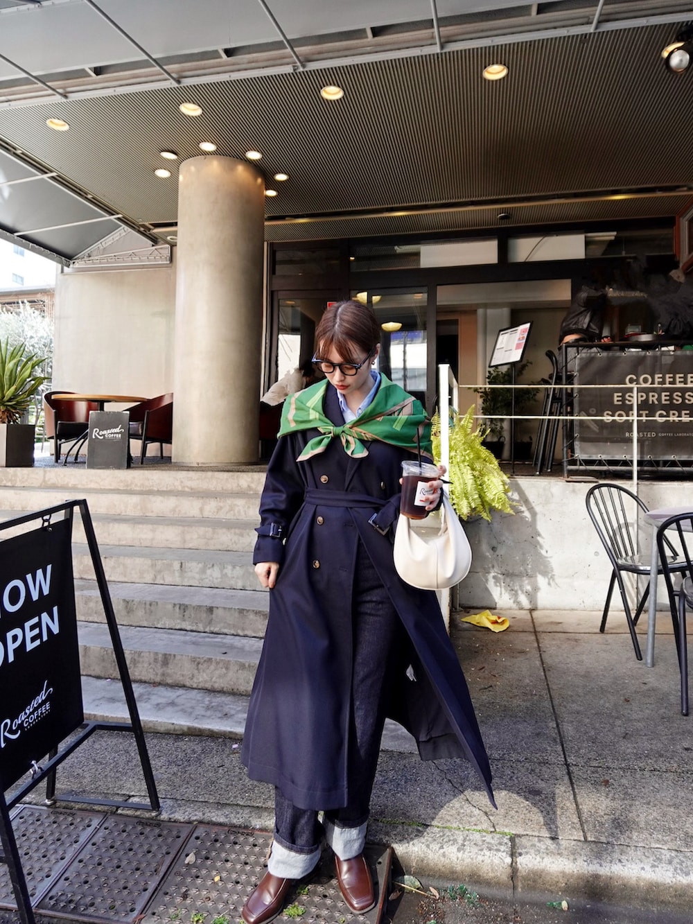 ブラウン系のパンプス、ホワイト系のハンドバッグ、ブルー系のトレンチコートを着用したレディースの春コーディネートの5枚目の写真