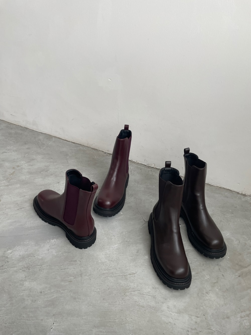 レッド系のブーツ、ベージュ系のシャツワンピース、ピンク系のバッグを着用したレディースの秋コーディネートの2枚目の写真