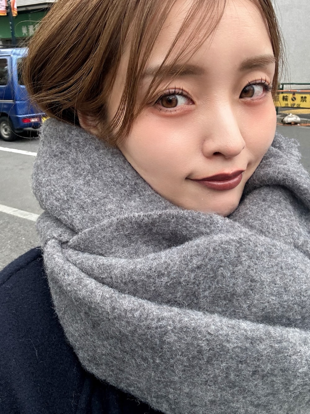 ブラック系のブーツ、ブルー系のチェスターコート、ベージュ系のショルダーバッグを着用したレディースの冬コーディネートの2枚目の写真