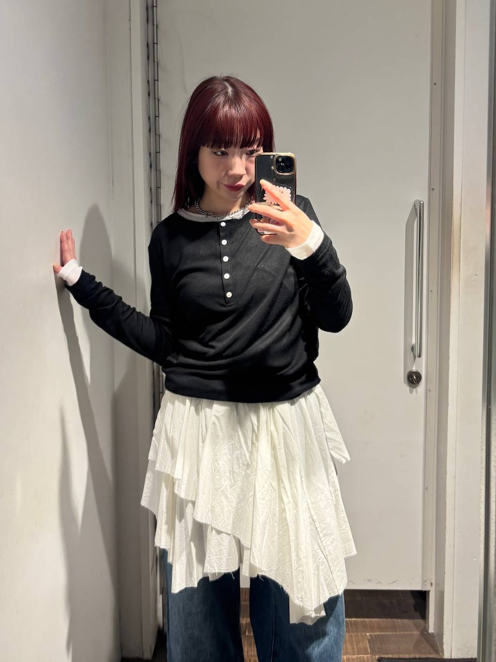 ブラウン系のパンプス、ブルー系のデニムパンツ、ホワイト系のスカートを着用したレディースの春コーディネートの2枚目の写真