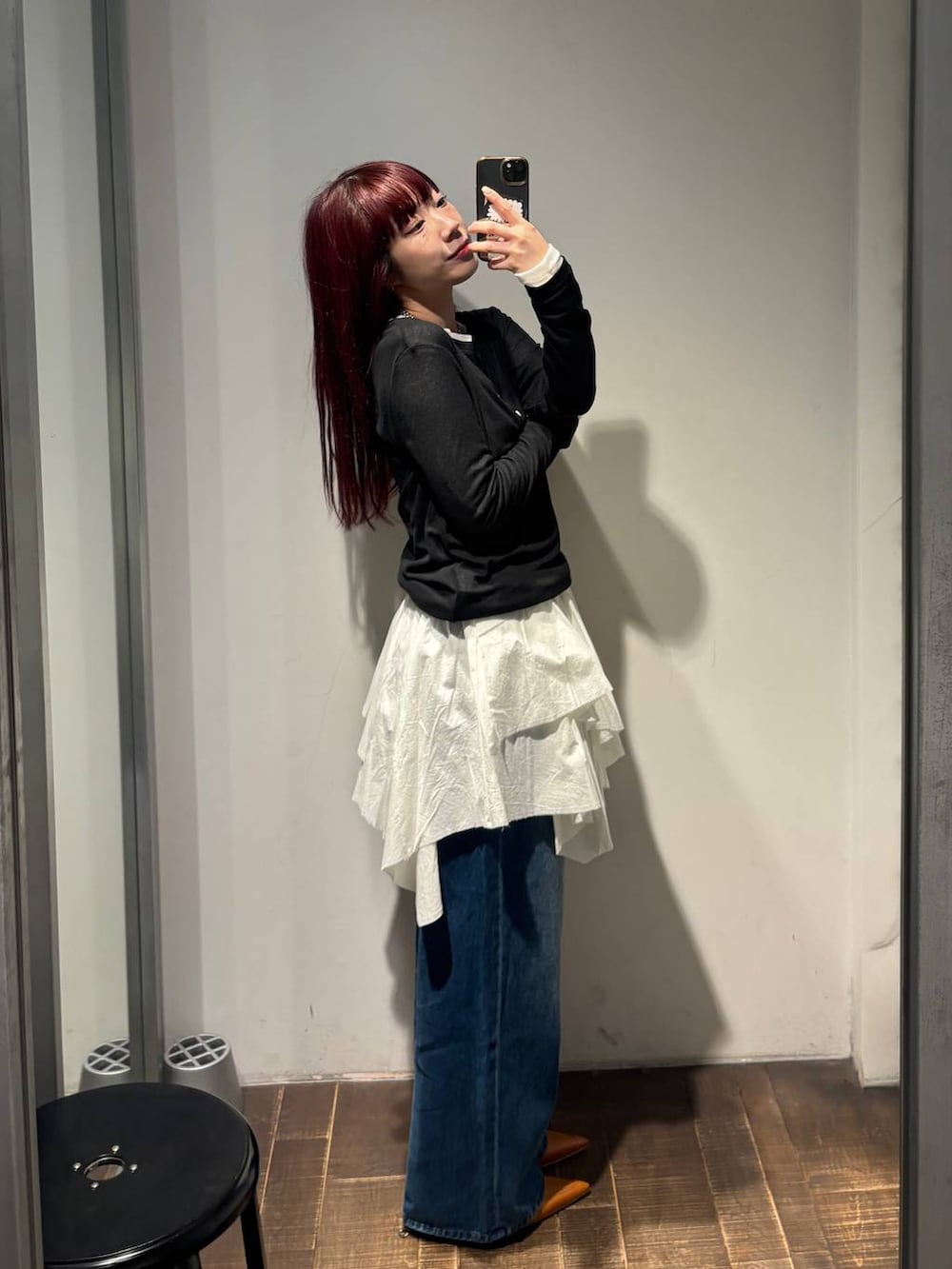 ブラウン系のパンプス、ブルー系のデニムパンツ、ホワイト系のスカートを着用したレディースの春コーディネートの3枚目の写真