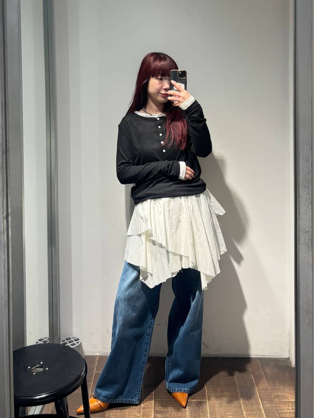ブラウン系のパンプス、ブルー系のデニムパンツ、ホワイト系のスカートを着用したレディースの春コーディネートの5枚目の写真