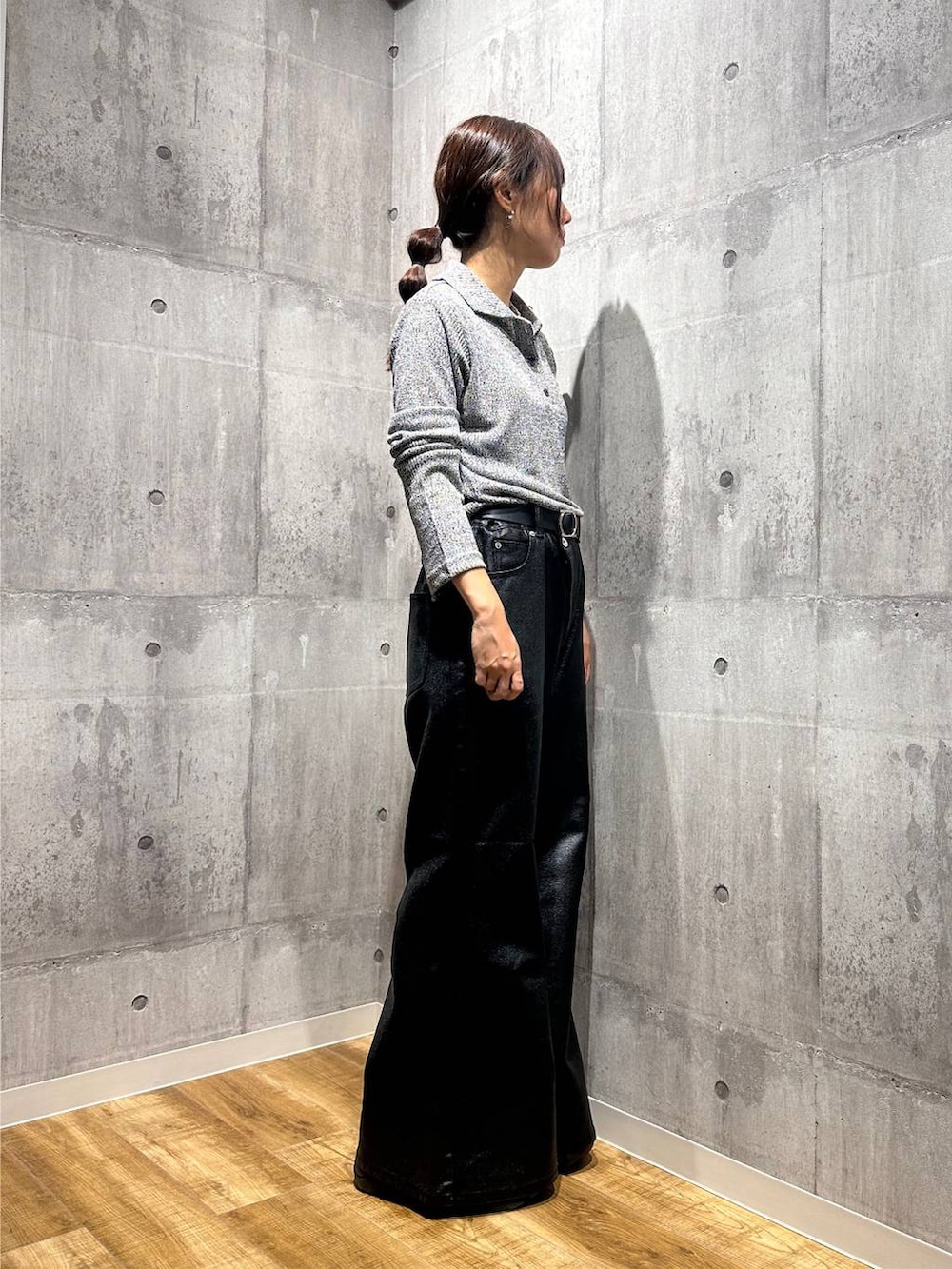 ブラック系のデニムパンツ、ブラック系のスニーカー、グレー系のニット/セーターを着用したレディースの秋コーディネートの2枚目の写真