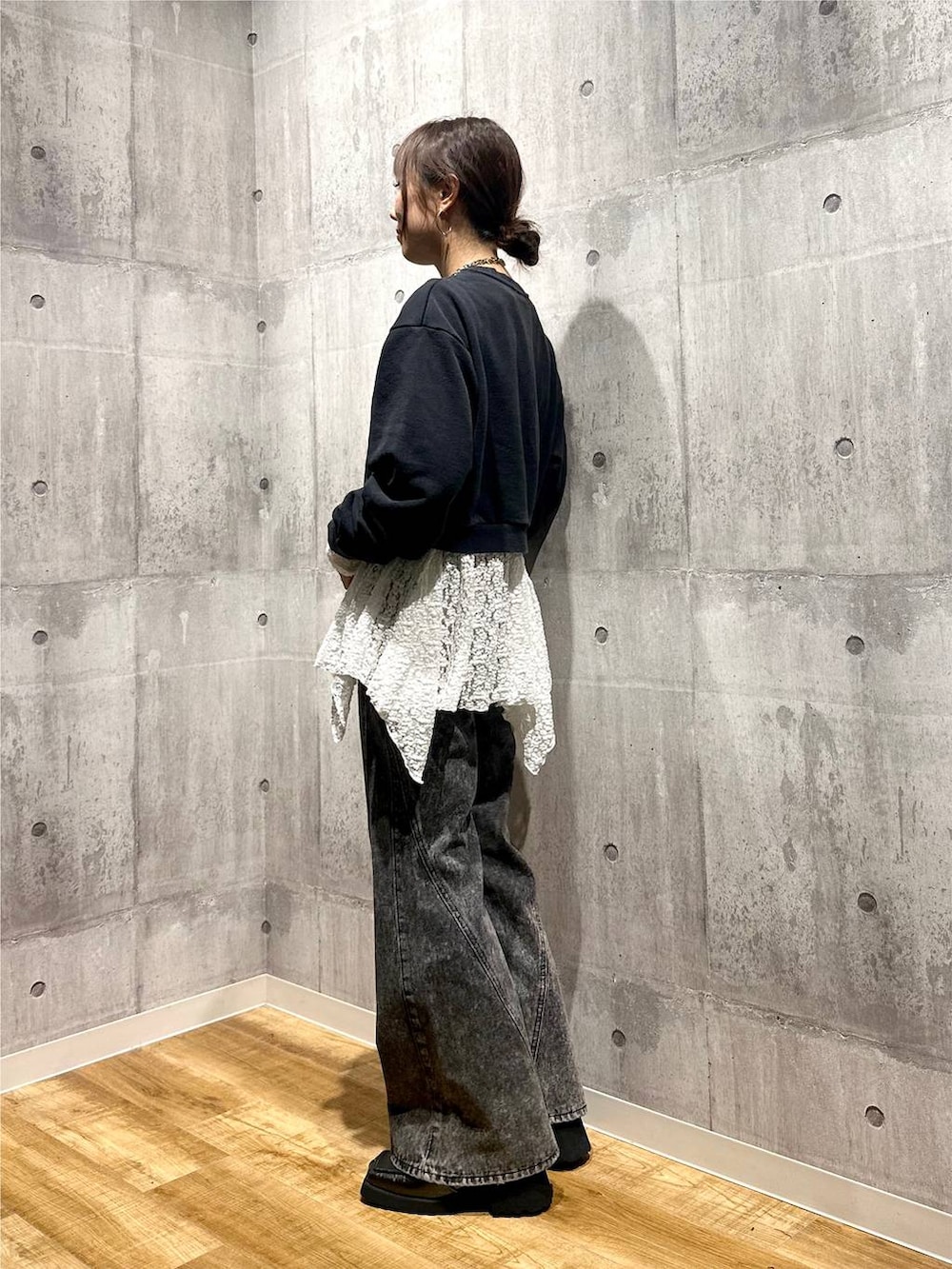 グレー系のスウェット、ブラック系のデニムパンツ、ホワイト系のチュニックを着用したレディースの秋コーディネートの2枚目の写真