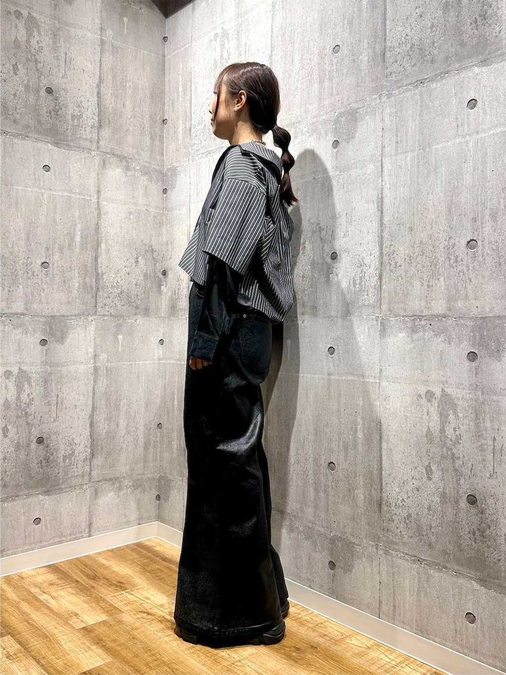 ブラック系のデニムパンツ、ブラック系のシャツ/ブラウス、ブラック系のスニーカーを着用したレディースの秋コーディネートの2枚目の写真
