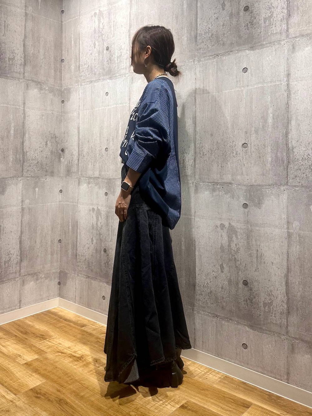 ブラック系のブーツ、ブラック系のデニムスカート、ブルー系のTシャツ/カットソーを着用したレディースの秋コーディネートの2枚目の写真