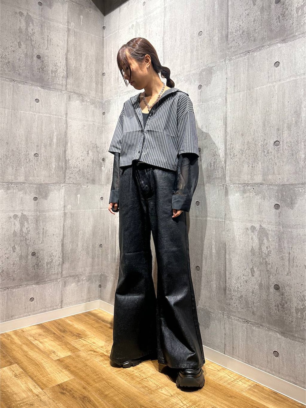 ブラック系のデニムパンツ、ブラック系のシャツ/ブラウス、ブラック系のスニーカーを着用したレディースの秋コーディネートの5枚目の写真