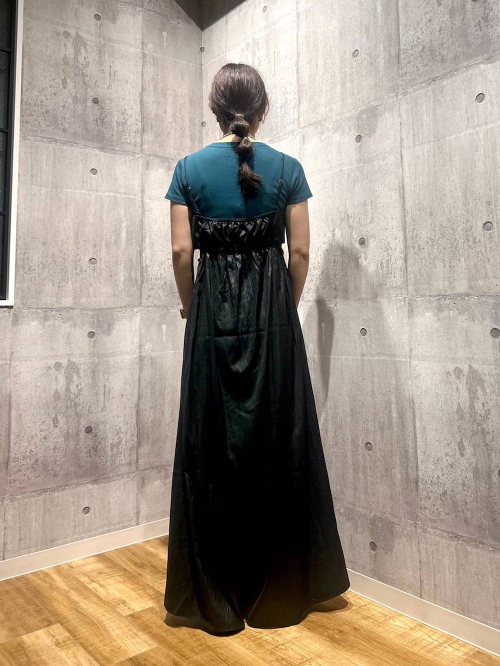 ブラック系のワンピース、ブラック系のサンダル、グリーン系のTシャツ/カットソーを着用したレディースの秋コーディネートの3枚目の写真