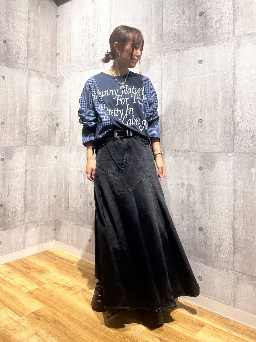 ブラック系のブーツ、ブラック系のデニムスカート、ブルー系のTシャツ/カットソーを着用したレディースの秋コーディネートの5枚目の写真
