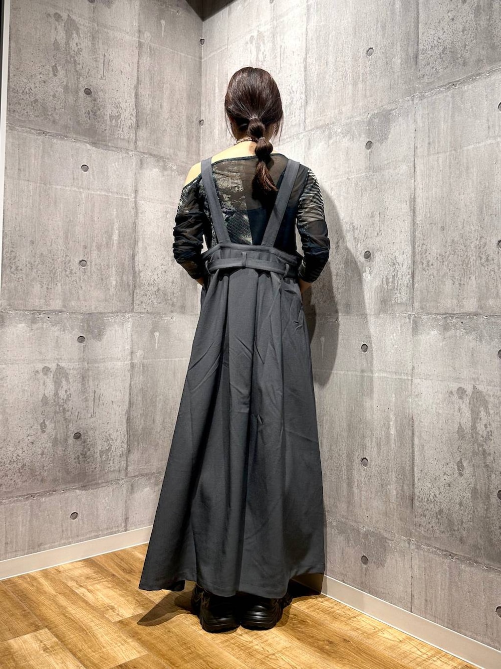 グレー系のジャンパースカート、ブラック系のスニーカー、グレー系のTシャツ/カットソーを着用したレディースの秋コーディネートの3枚目の写真