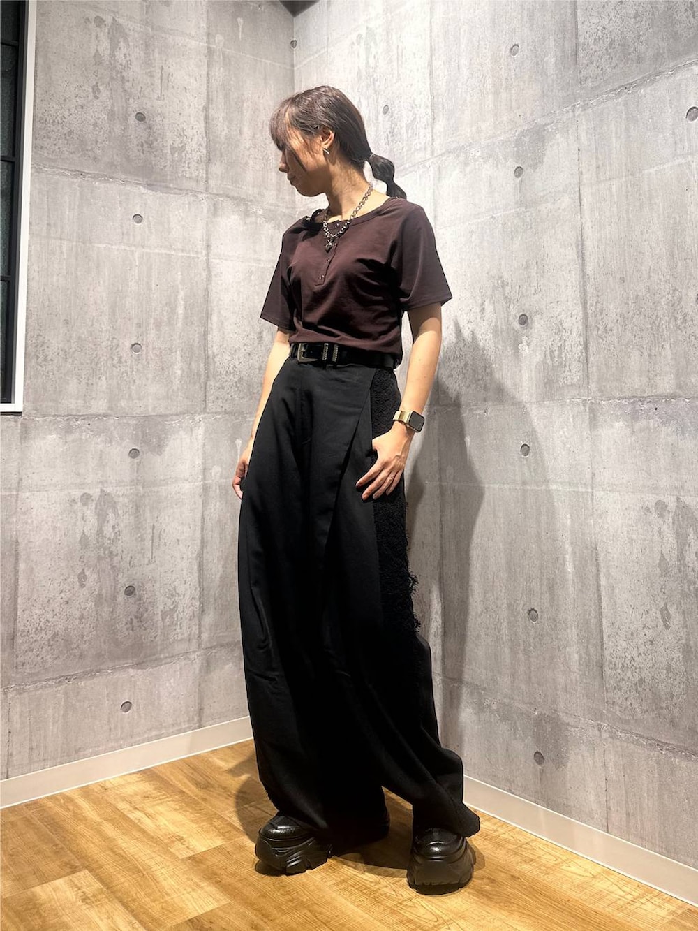ブラウン系のTシャツ/カットソー、ブラック系のスラックス、ブラック系のスニーカーを着用したレディースの秋コーディネートの2枚目の写真