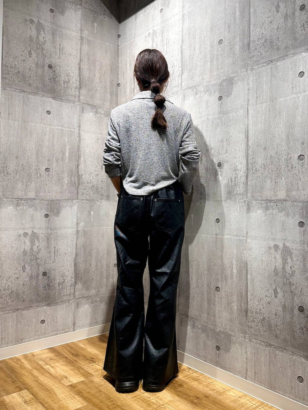 ブラック系のデニムパンツ、ブラック系のスニーカー、グレー系のニット/セーターを着用したレディースの秋コーディネートの3枚目の写真