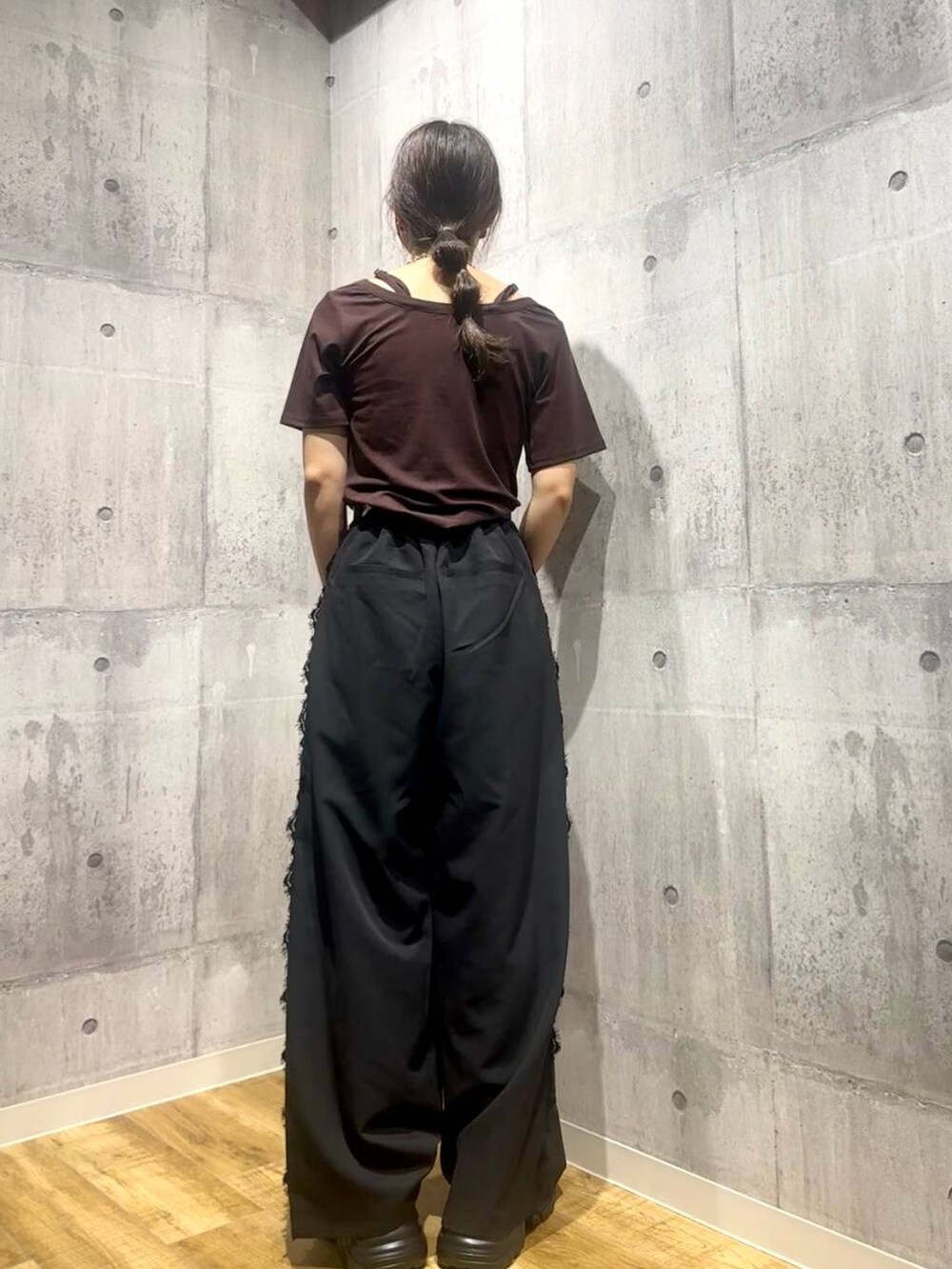 ブラウン系のTシャツ/カットソー、ブラック系のスラックス、ブラック系のスニーカーを着用したレディースの秋コーディネートの3枚目の写真