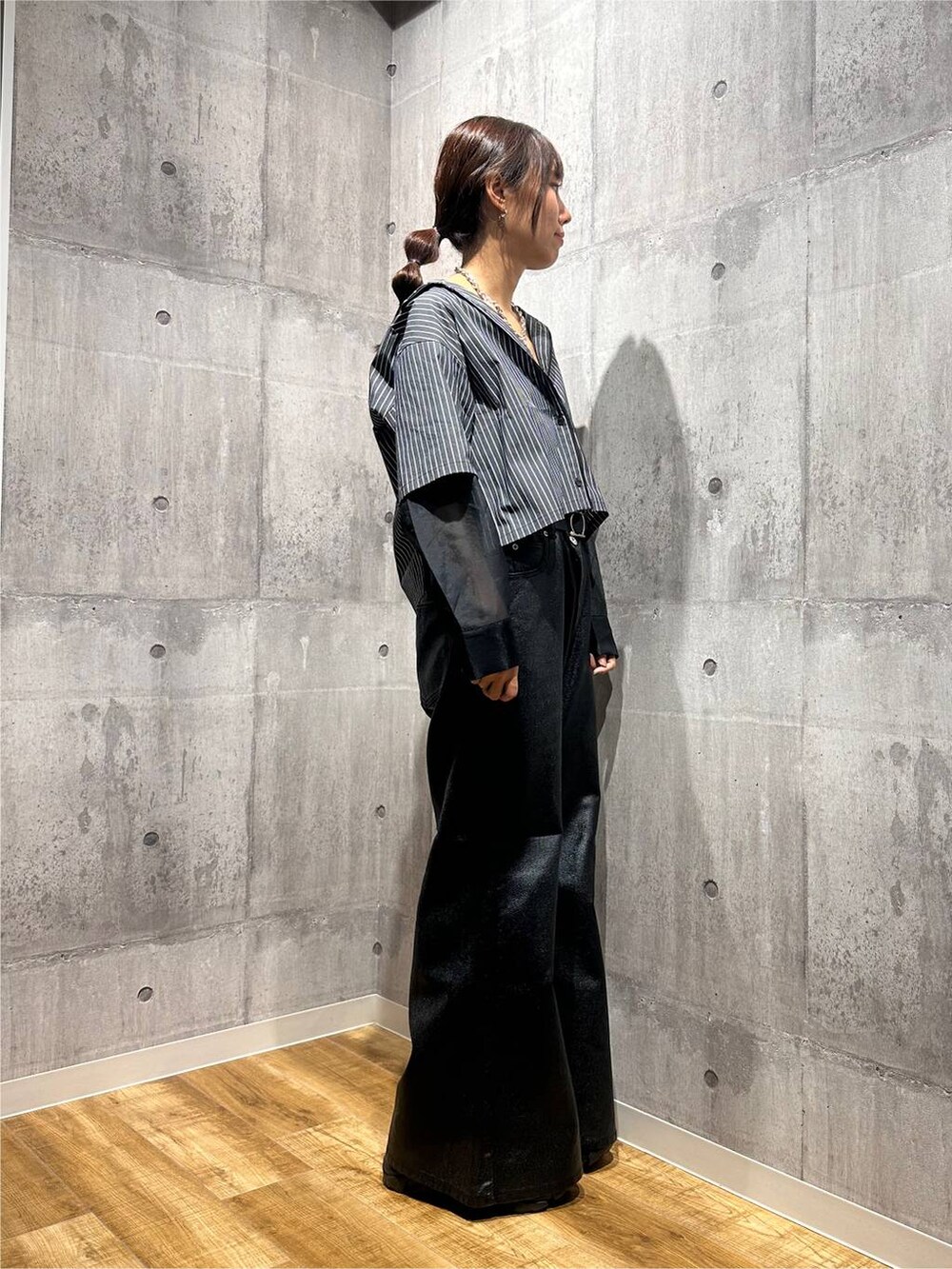 ブラック系のデニムパンツ、ブラック系のシャツ/ブラウス、ブラック系のスニーカーを着用したレディースの秋コーディネートの4枚目の写真