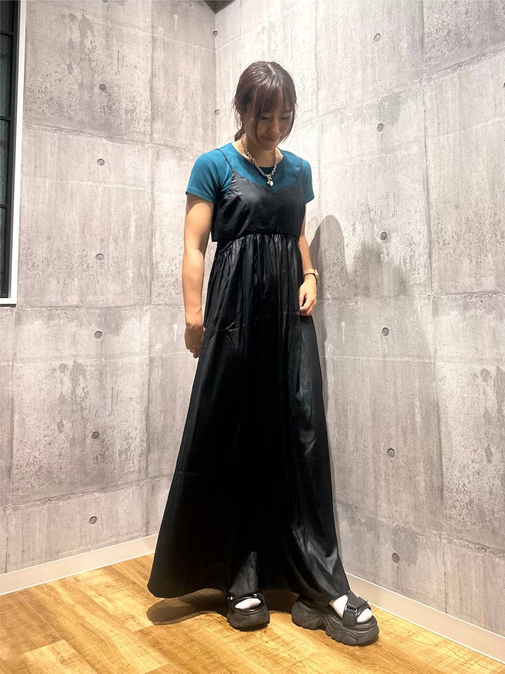 ブラック系のワンピース、ブラック系のサンダル、グリーン系のTシャツ/カットソーを着用したレディースの秋コーディネートの5枚目の写真