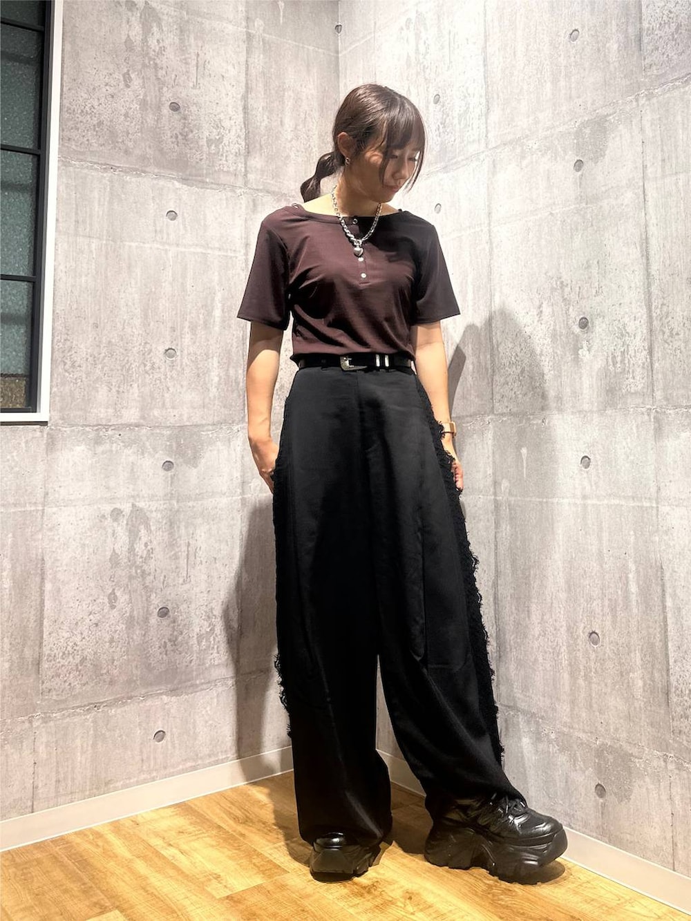 ブラウン系のTシャツ/カットソー、ブラック系のスラックス、ブラック系のスニーカーを着用したレディースの秋コーディネートの5枚目の写真