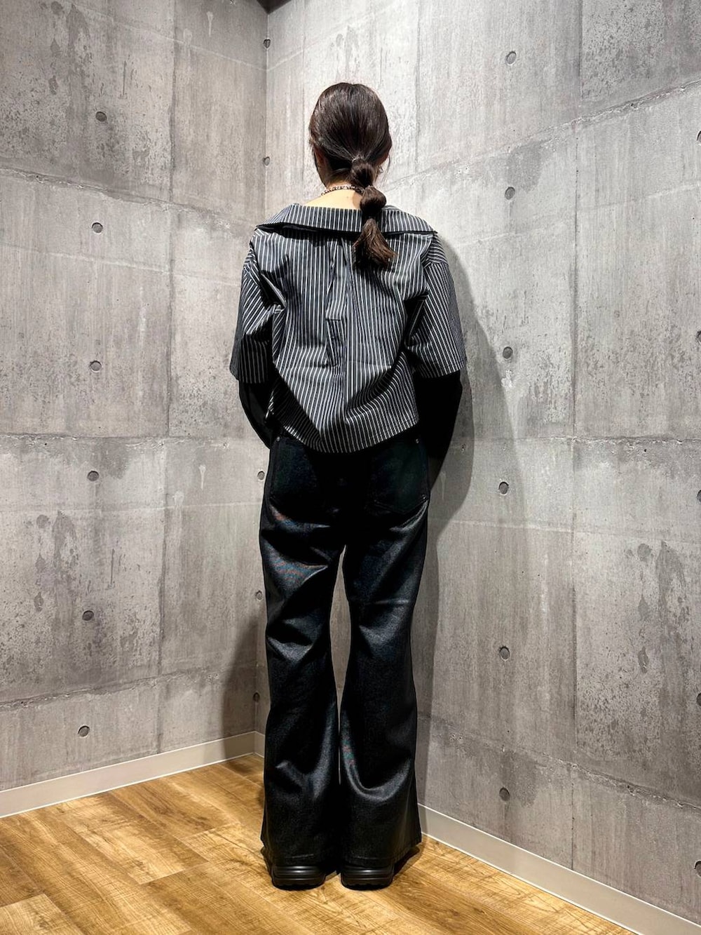 ブラック系のデニムパンツ、ブラック系のシャツ/ブラウス、ブラック系のスニーカーを着用したレディースの秋コーディネートの3枚目の写真