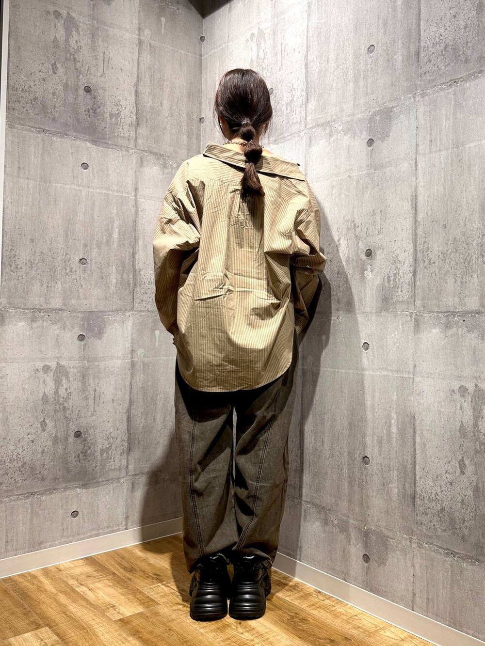 ブラウン系のデニムパンツ、ブラック系のスニーカー、ベージュ系のシャツ/ブラウスを着用したレディースの秋コーディネートの3枚目の写真